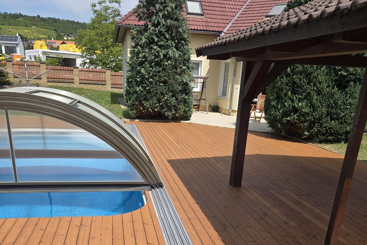 Dřevěná terasa kolem bazénu a pergoly